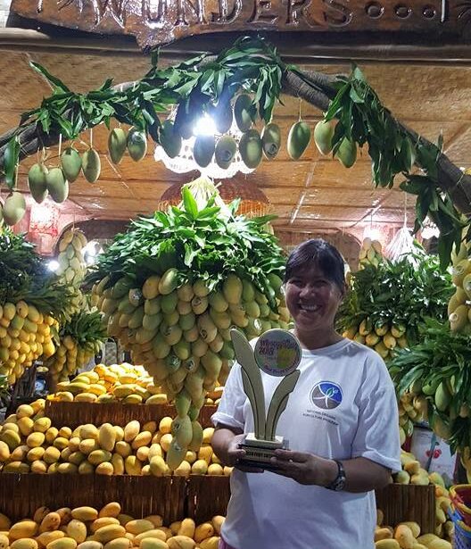 Rose Griesser at the farm’s market stall under the carved Guimaras Wonder’s Farm sign